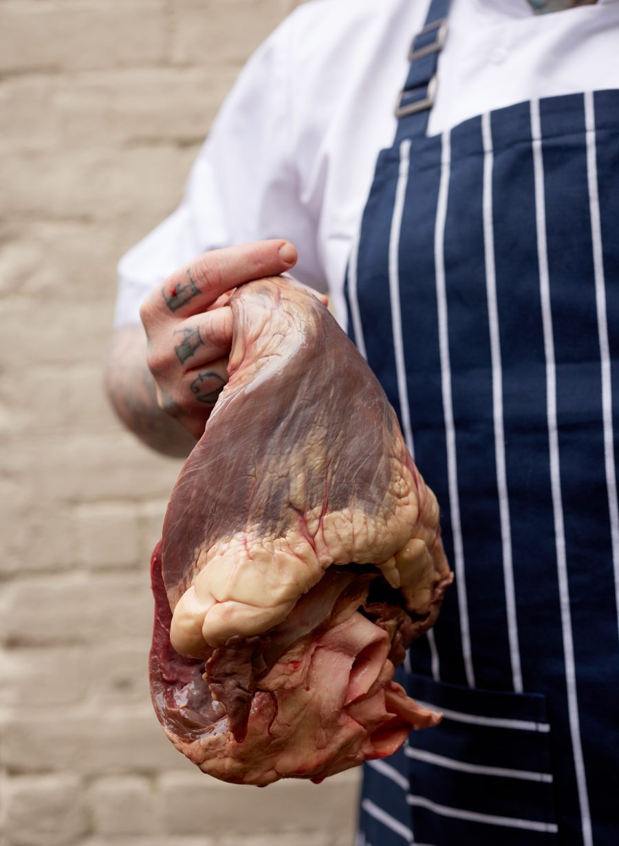 kitchen staff holding cuts of meat